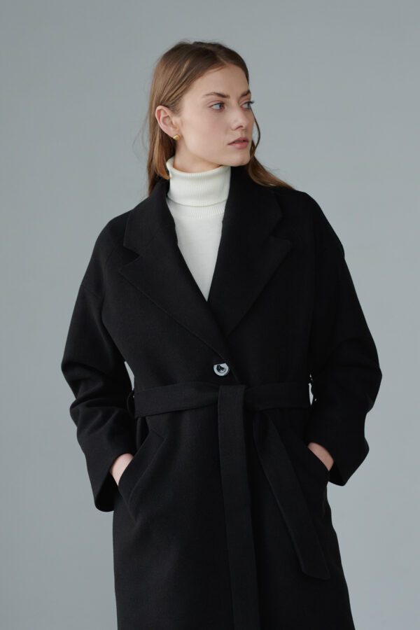 Obszerny płaszcz jednorzędowy typu oversize, do połowy łydki, wiązany, zapinany na guziki, raglanowe rękawy, edycja limitowana.