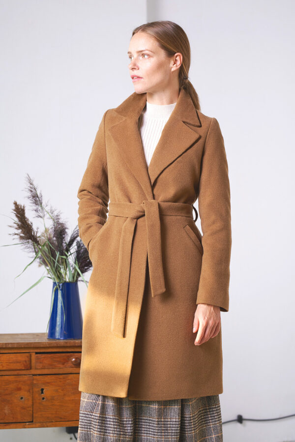 Damski płaszcz wełniany z paskiem w kolorze kamelowym.