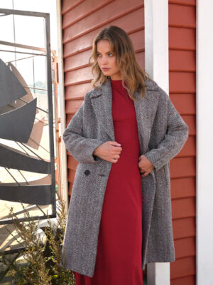 Oversizowy płaszcz o luźniejszym kroju w ponadczasowy wzór jodełki. Stylowy i wygodny.