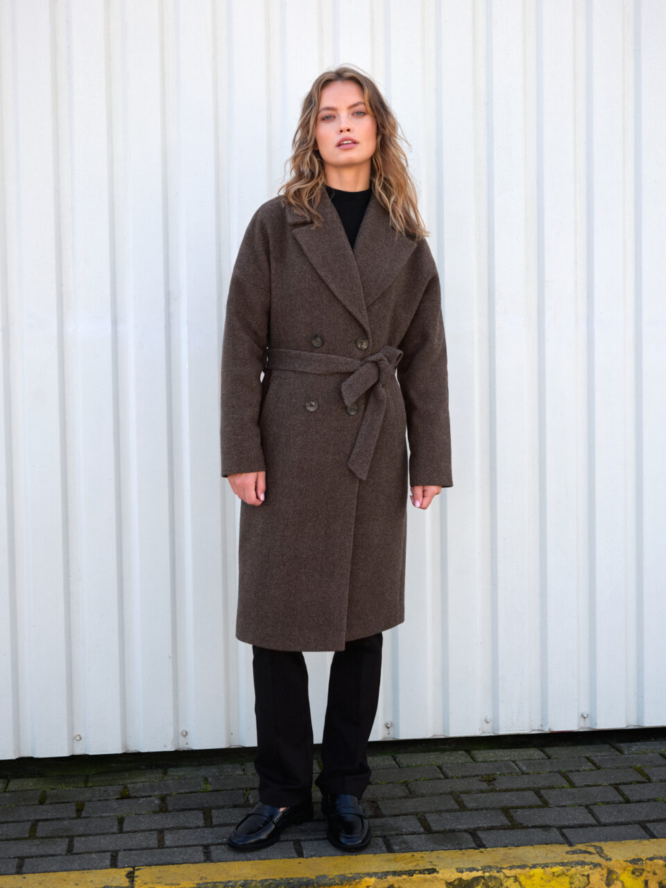 Oversizowy płaszcz zimowy celowo przeskalowany swobodny krój. Zapinany dwurzędowo i wiązany. W jodełkę. Ocieplany.