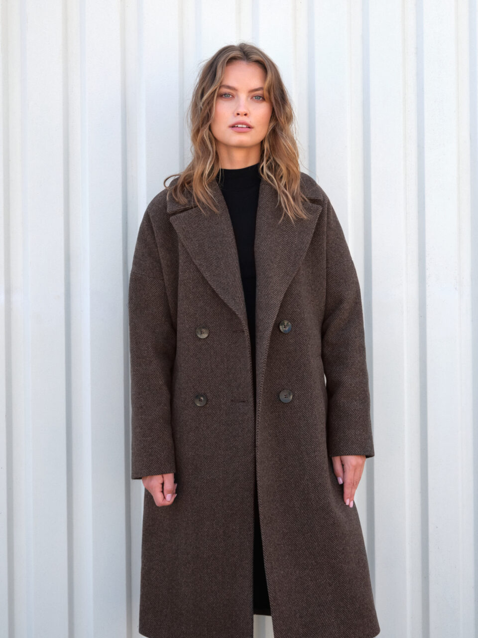 Zimowy płaszcz damski z opuszczoną linią ramion w stylu oversize. W jodełkę. Nowoczesna linia, klasyczny wzór. Wełniany materiał.