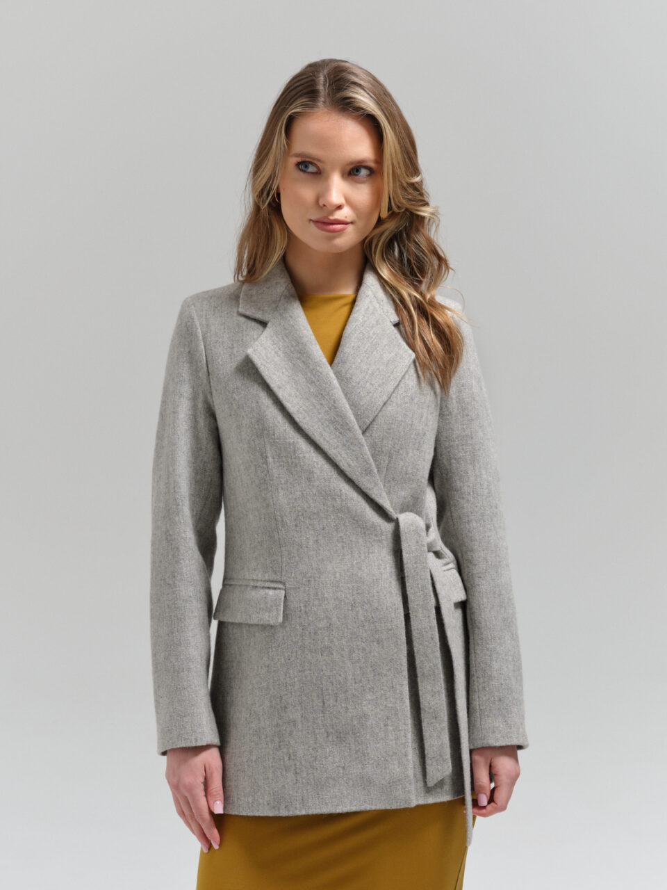 Jasnoszara marynarka wełniana wiązana finezyjnie z boku. Dopasowana do sylwetki. Produkt premium.