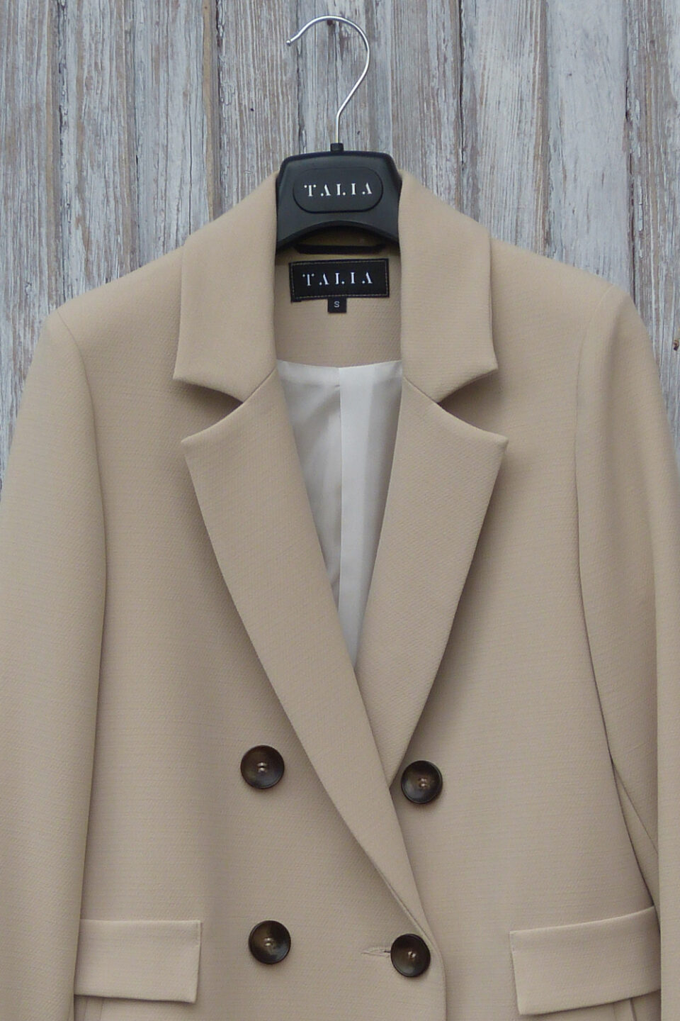 Dwurzędowy trencz o fasonie luźnej marynarki z szylkretowymi guzikami.