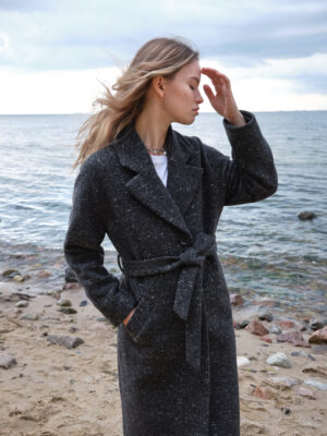 Czarny melanżowy płaszcz wełniany z mięsistego materiału. Jednorzędowy, zapinany na guziki. Wiązany w pasie. Idealnie sprawdzi się zimą. Ocieplany.