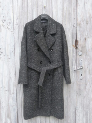 Czarny melanżowy płaszcz zimowy w stylu oversize, zapinany na guziki i wiązany w pasie. Uszyty z przepięknego materiału wełnianego z dodatkiem kaszmiru.