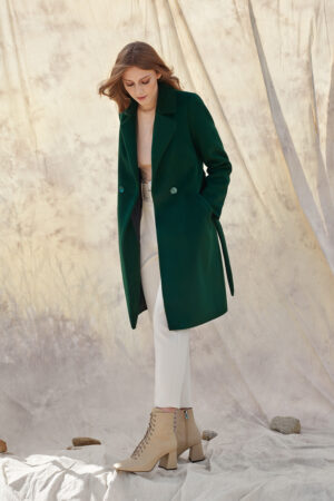 Damski płaszcz z paskiem, zapinany na guziki, w kolorze butelkowej zieleni.