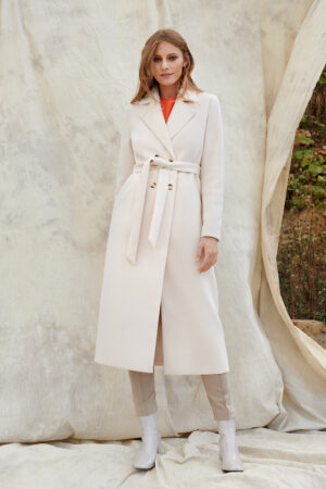 Długi płaszcz damski w kolorze mlecznej bieli.
