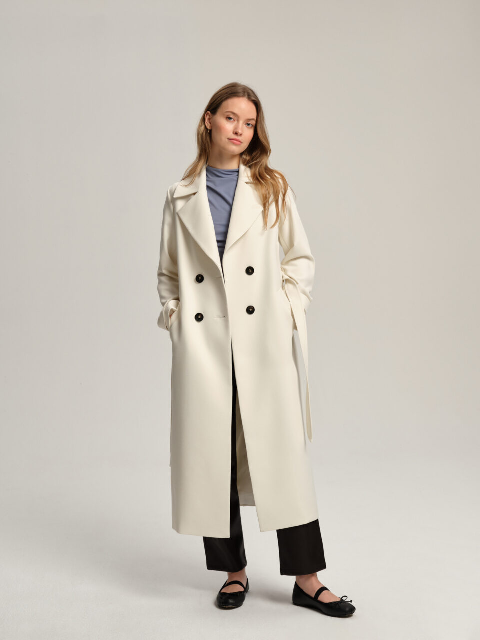 Długi trencz damski o klasycznym kroju, taliowany tył, profilowany przód. Wiązany. Uszyty z plasycznego lekkiego materiału i acetatowej podszewki. Kołnierz typy rewers. Podstawa wielu wiosennych stylizacji.