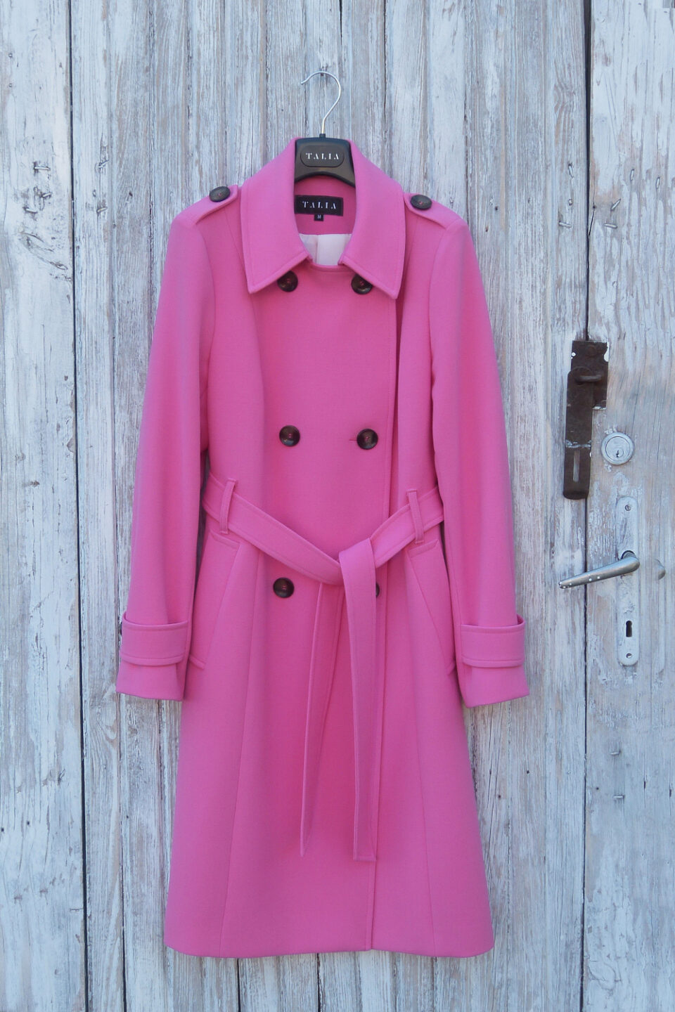 Dopasowany trencz damski z paskiem zapinany na guziki.