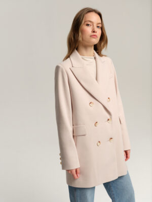 Dwurzędowa marynarka w jodełkę. Luźny krój. Długość do połowy uda. Klasycznie wszywany rękaw, wykończony ręcznie przyszywanymi guzikami. Dwie kieszenie z patką. Brustasza.