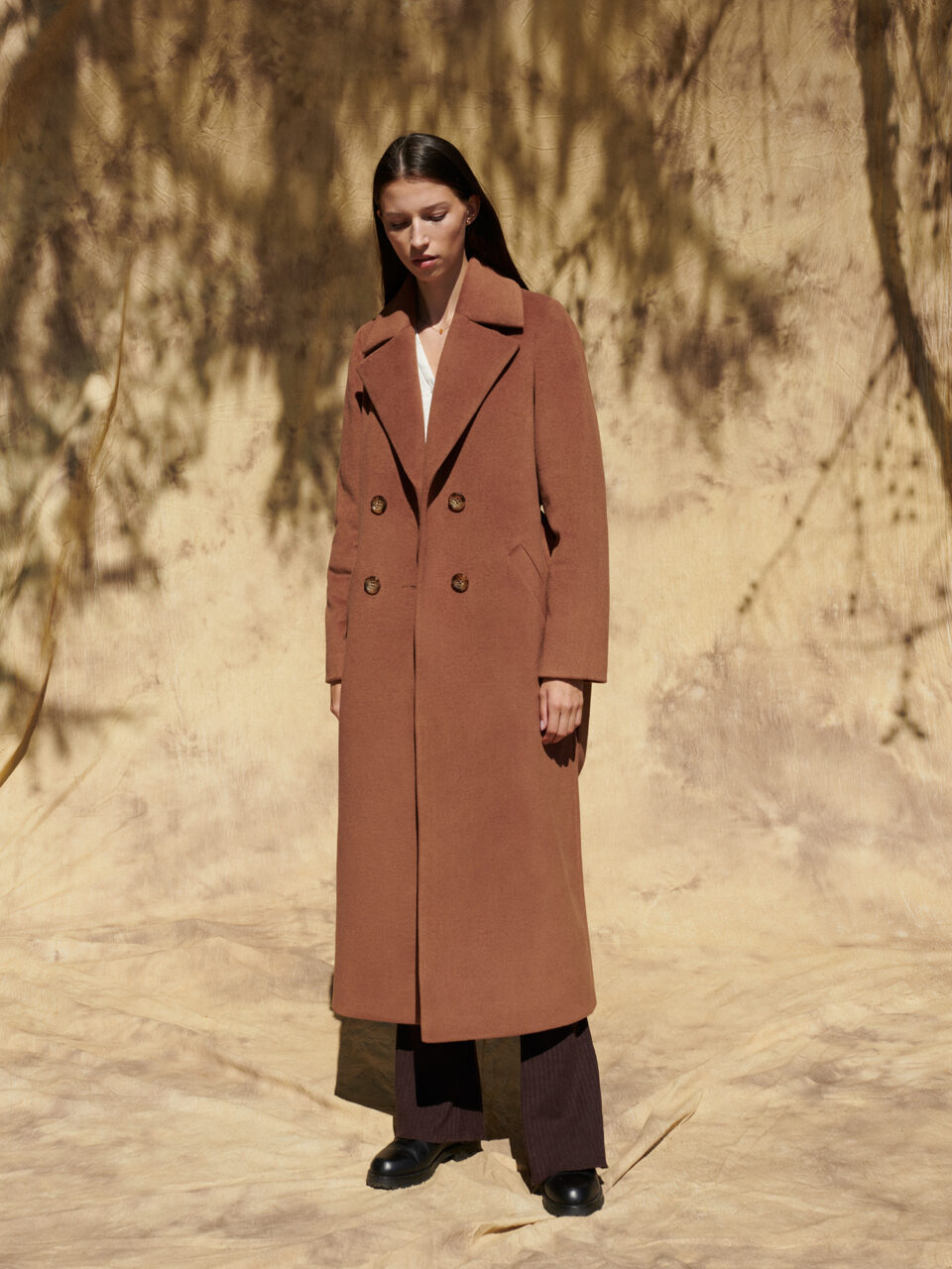 Dwurzędowy, długi płaszcz damski z szylkretowymi guzikami.