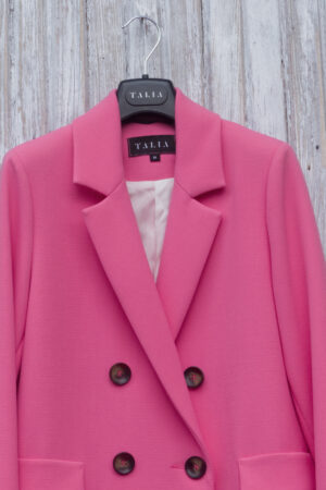 Krótki trencz o kroju dwurzędowej marynarki, z wykładanym kołnierzem typu rewers.