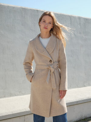 Jednorzędowy płaszcz wełniany o asymetrycznym przodzie. Zapinany na ręcznie przyszywane guziki. Szykowny szalowy kołnierz tworzący stójkę. Uszyty z wełny dziewiczej w beżową jodełkę.