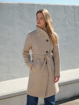 Jednorzędowy płaszcz zimowy z otulającym kołnierzem podpinanym w stójkę. Nowoczesna, asymetryczna linia bez zbędnych odób, jedynie piękny wzór jodełki i ręcznie przyszywane guziki. Wiązany w pasie.