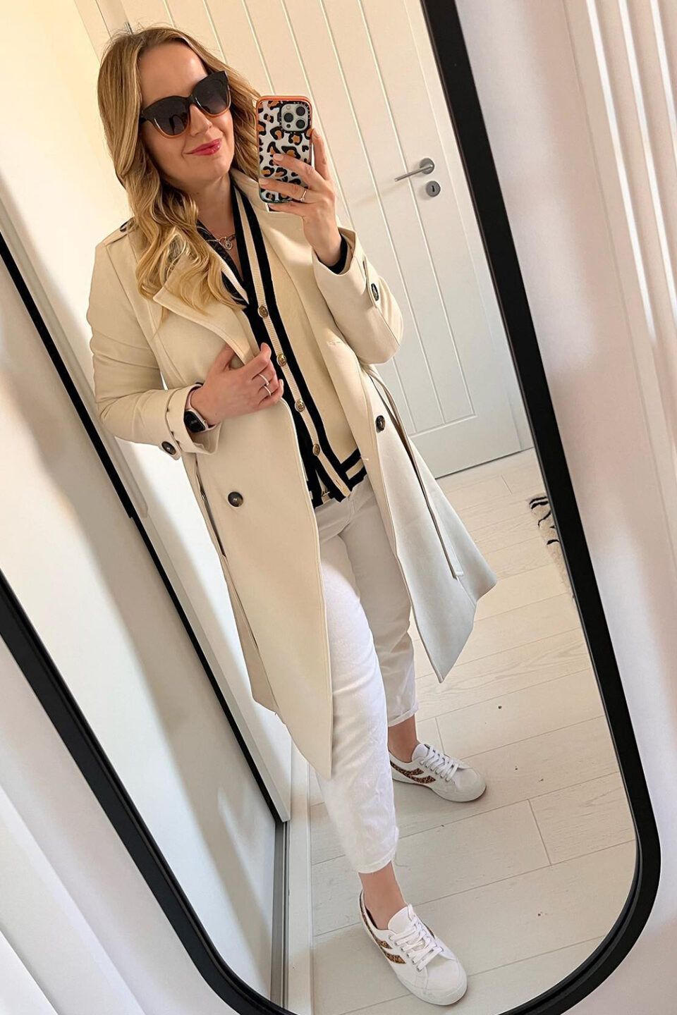 Trencz dwurzędowy dopasowany w kolorze kremowym a szylkretowymi guzikami.