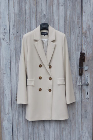 Dwurzędowa kurtka w stylu marynarki, guziki szylkretowe, kołnierz rewers, ozdobne patki nad kieszeniami.