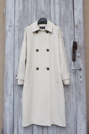 Damski oversizowy trencz w śmietankowym kolorze zapinany na guziki.