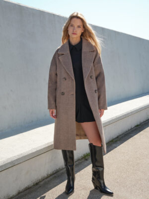Swobodny krój, opadające miękko ramiona oraz miękki material zapewnią komfort noszenia i nowoczesny look. Zimowy płaszczyk w brązową jodełkę uszyty z materiału z deadstocku, zgodnie z filozofią zrównoważonej mody.