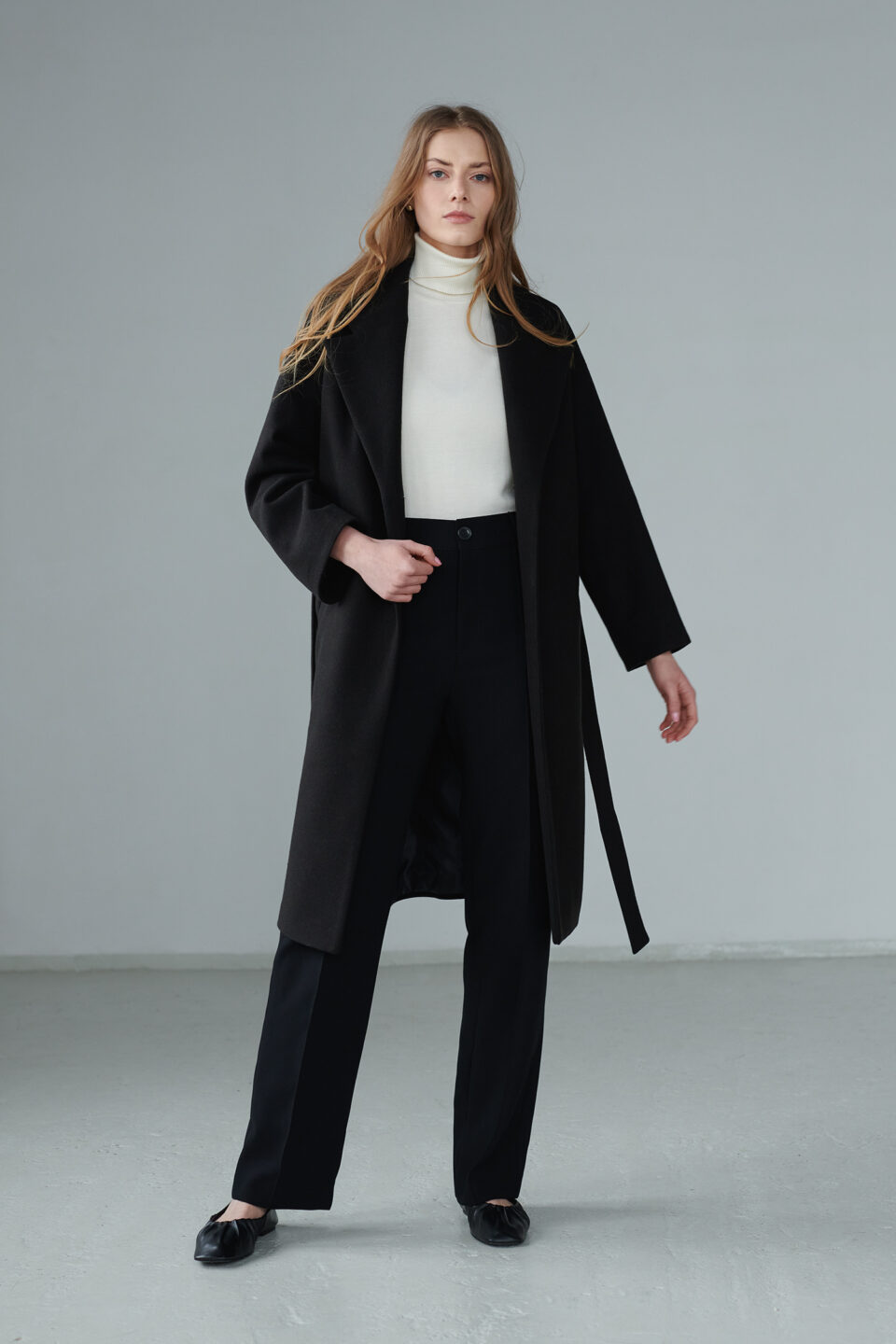 Oversizowy płaszcz jednorzędowy, zapinany na guziki, wiązany, z mieszanki wełny.