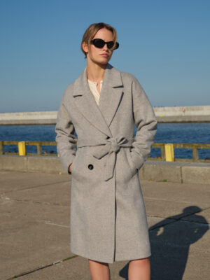 Oversizowy płaszcz damski zimowy o obniżonej linii ramion. Pudełkowy krój z kołnierzem z klapami w stylu vintage. W ponadczasową jodełkę w stonowanej kolorystyce. Klasyka w nowoczesnej odsłonie.