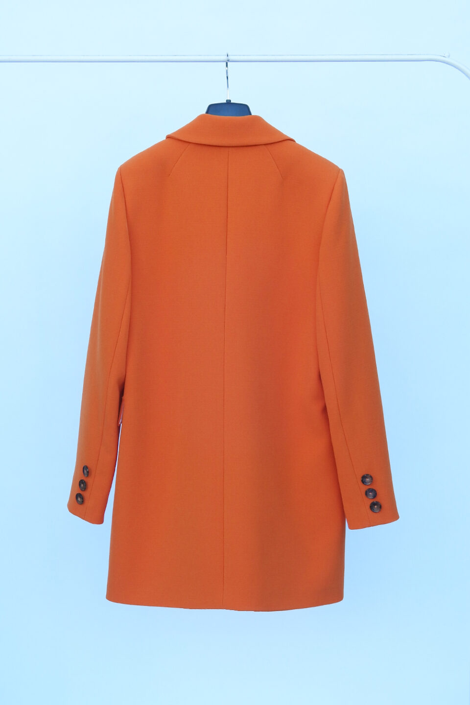 Wiosenna marynarka płaszczyk damski w kolorze pomarańczowym ozdobne guziki na rękawach.