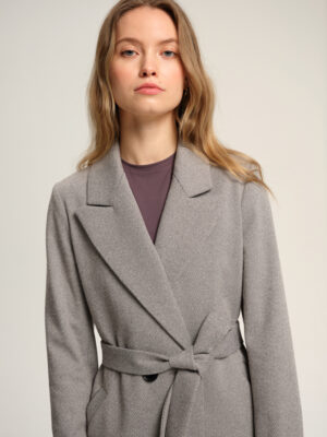 Płaszcz przejściowy w czarno-białą jodełkę. Uszyty z bawełnianej mieszanki i acetatowej podszewki. Idealny na wiosnę i jesień. Materiał i podszewka zapewnią komfort noszenia mimo zmieniającej się pogody. Taliowany. Z paskiem. Klasycznie wszywany rękaw. Kołnierz typu rewers.