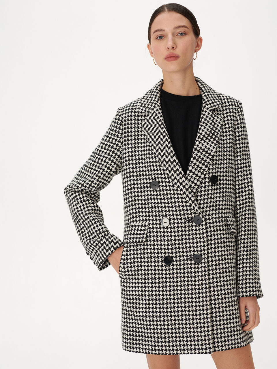 Płaszcz jak marynarka dwurzędowa zapinana na guziki w czarno-białą pepitkę.