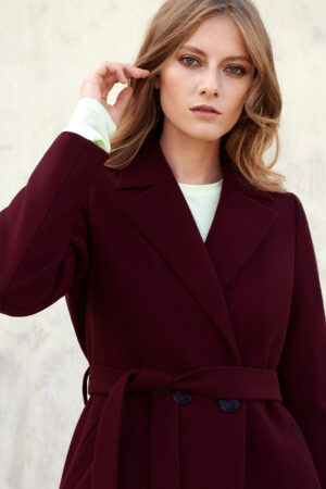 Bordowy płaszcz zimowy o wygodnej długości w kolano. Szlafrokowy wygodny krój. Wiązany i zapinany na guzik.