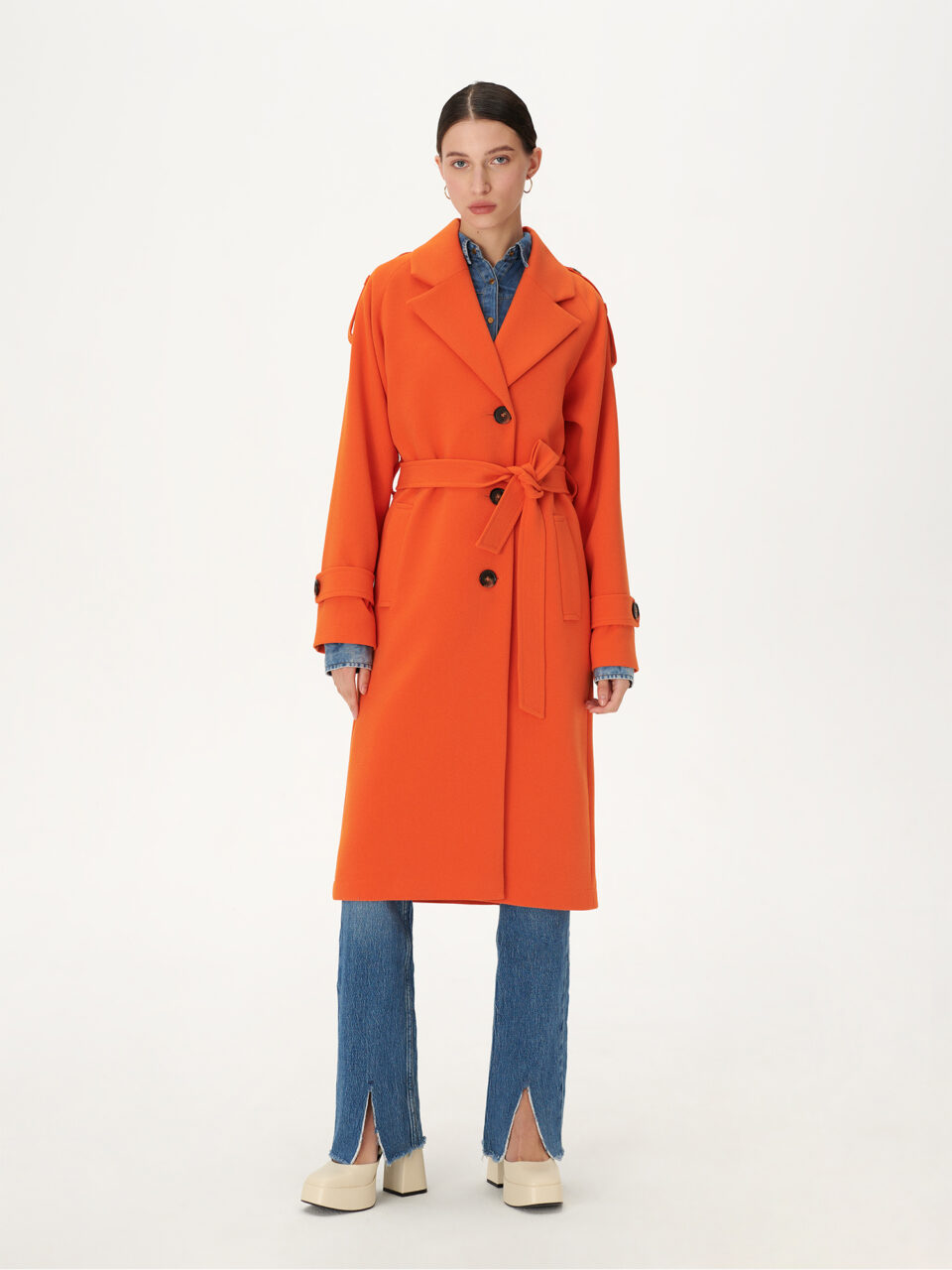 Długi, jednorzędowy trencz w modnym kolorze pomarańczowym. Luźny fason, wiązany. Dopamine dressing.