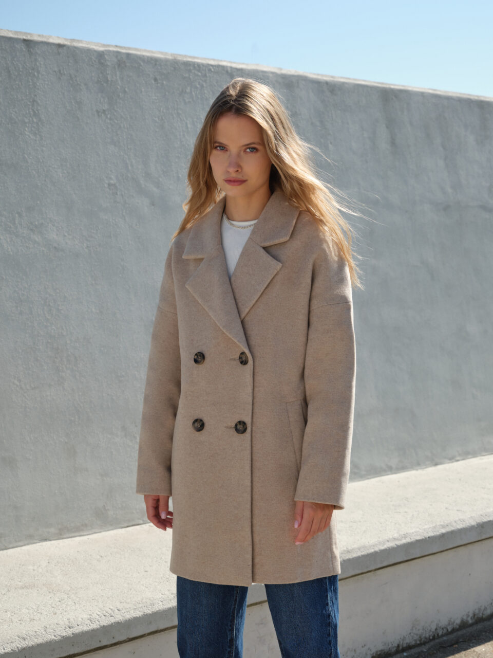 Wełniana kurtka beżowa o kroju boxy średniej długości w stylu hygge. Idealna na zimę. Wygodna i pomieści wielowarstwowe stylizacje.