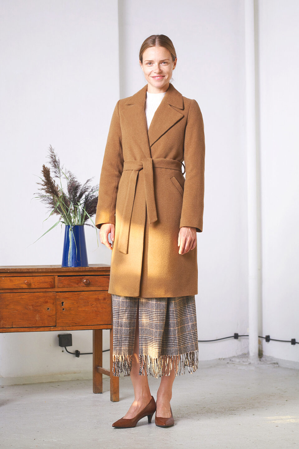 Płaszcz z delikatnymi połami ocieplany w kolorze kamelowym.