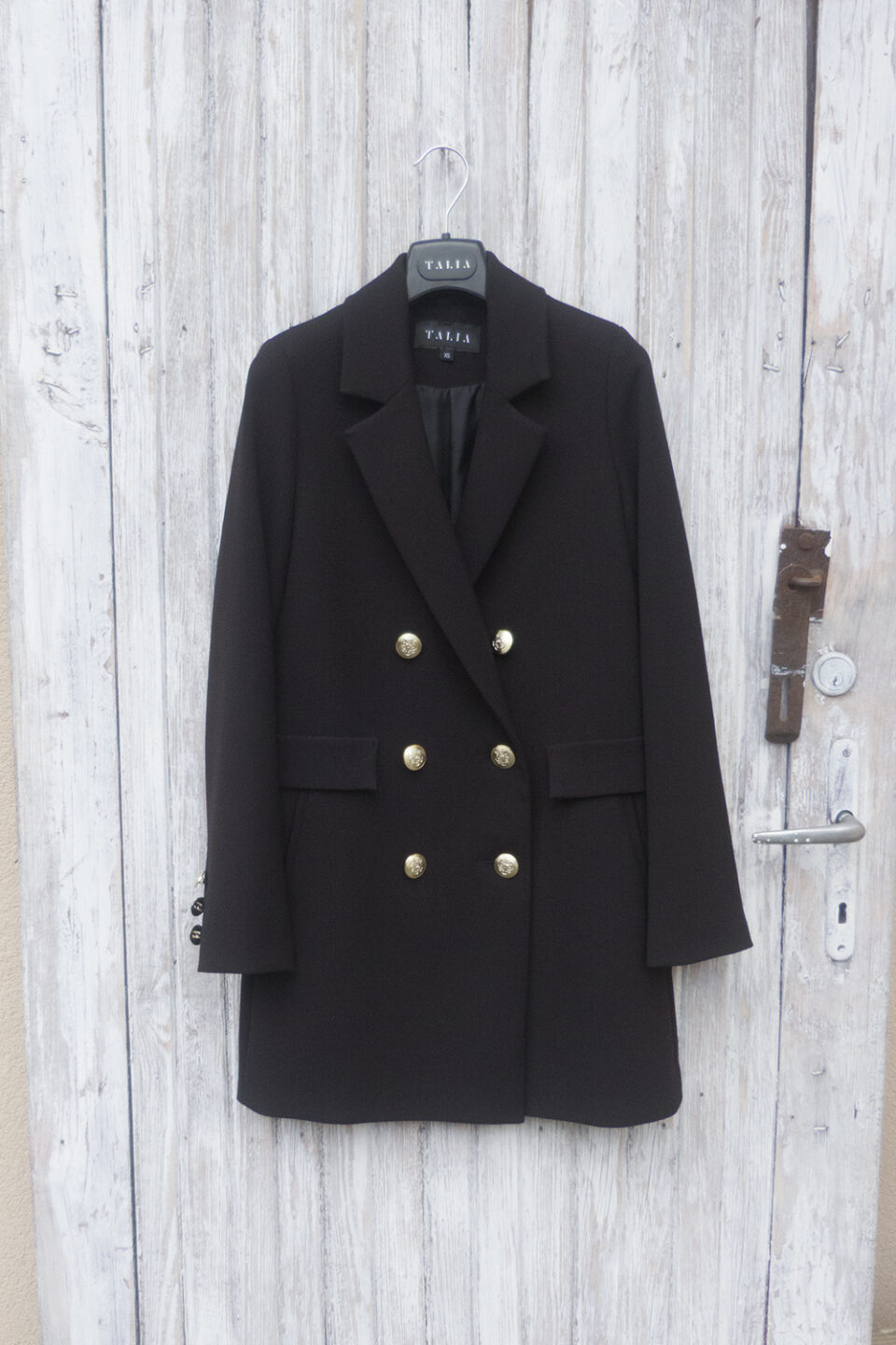 Czarny płaszczyk wiosenny ze złotymi guzikami.