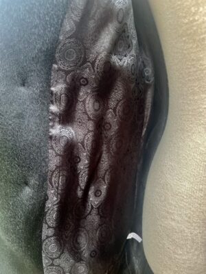 Podszewka wiskozowa, oddychająca, miękka i we wzór. Głęboka czerń materiału i lśniący materiał w zimowym, grubym, długim płaszczu zimowym.