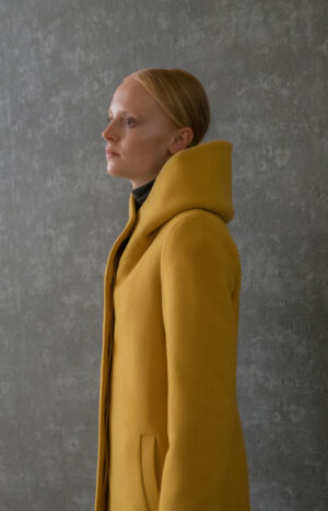 Zimowy płaszcz damski z kapture. Zapinany na guziki. Dopasowany tył. Prosty krój. Minimalistyczny styl. Płaszcz w stylu retro.