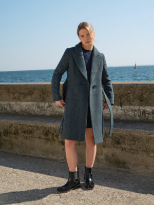 Zimowy płaszczyk w kolano. Uszyty z wełny dziewiczej, która zapewni komfort termiczny i doda szyku w zimowe, pochmurne dni. Wiązany w pasie. Jodełka butelkowa zieleń.