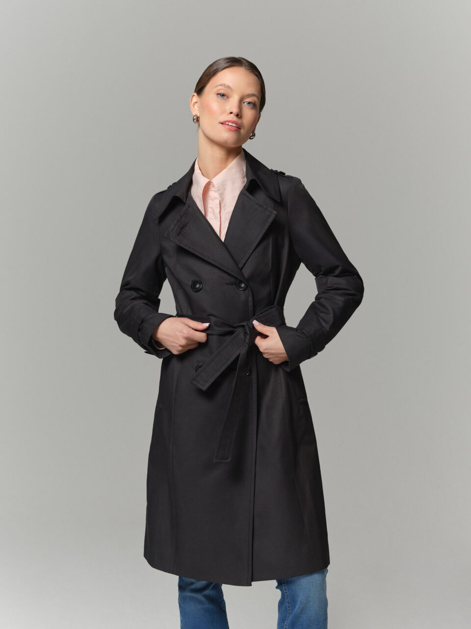 Czarny trencz damski o klasycznym kroju. Uszyty z bawełnianej tkaniny z powłoką hydrofobową. Zapinany dwurzędowo.