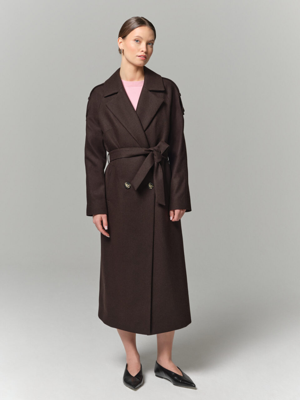 Czekoladowy długi trencz wełniany z paskiem. Lekkie okrycie wierzchnie o swobodnym kroju.