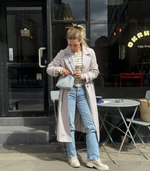 Długi bawełniany trencz damski w jasnym popielu. Zapinany na guziki i wiązany.