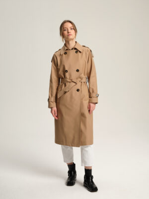 Długi trencz damski w luźnym stylu z tkaniny bawełnianej z powłoką hydrofobową w ciepłym, beżowym kolorze.