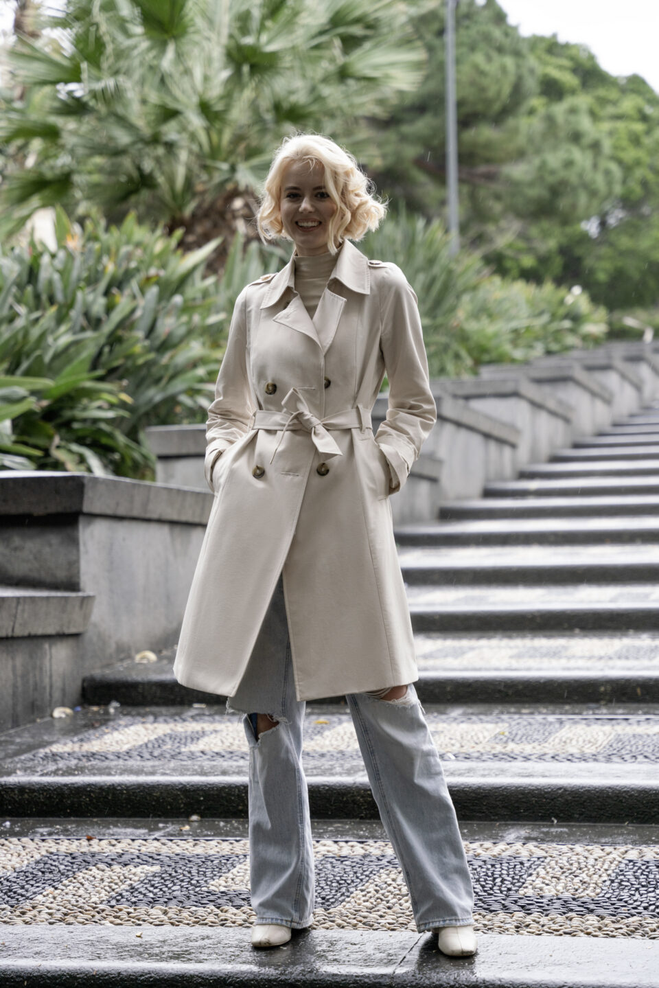 Dwurzędowy trencz damski o klasycznym taliowanym kroju. Uszyty z tkaniny bawełnianej pokrytej powłoką hydrofobową.