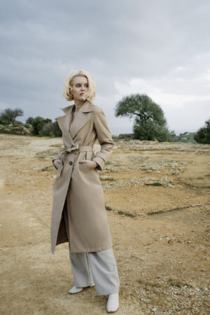 Klasyczny trencz damski o dopasowanym minimalistycznym kroju. Długość do połowy łydki. Bazowy kolor.