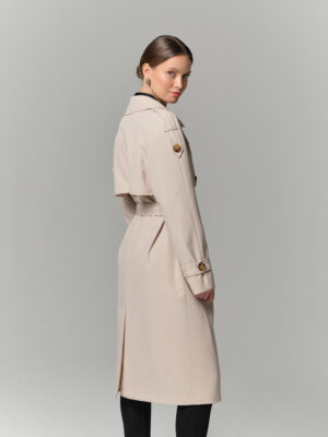 Kremowy trencz z mieszanki bawełny pokrytej hydrofobową powłoką. Raglanowy rękaw, kołnierz rewers i peleryna.