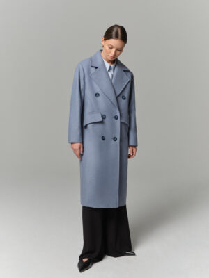 Niebieski pudełkowy płaszcz damski. Luźny, swobodny krój z obniżoną linią ramion. Zapinany na guziki. Ozobne patki na przodzie.