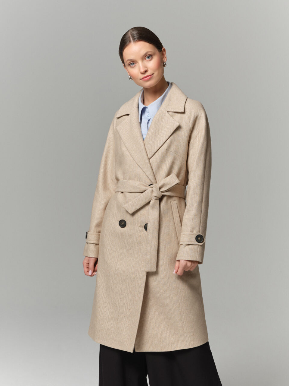 Płaszcz przejściowy na wiosnę i jesień z lżejszej tkaniny z przewagą wełny. Ponadczasowy wzór jodełki w beżowych odcieniach.