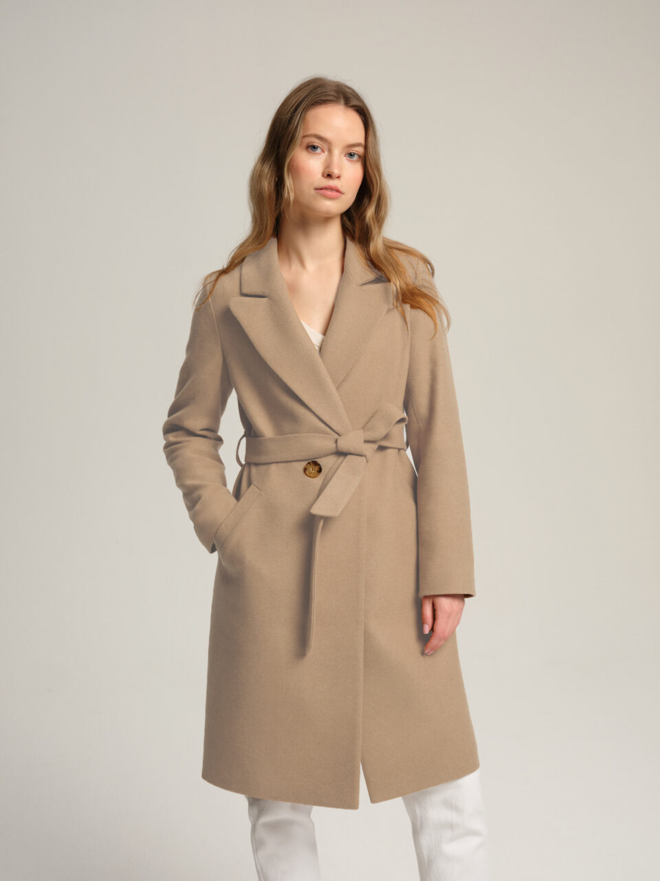 Płaszczyk przejściowy z lekkiej mieszanki wełny i kaszmiru w beżowym kolorze. Na podszewce. Wiązany.