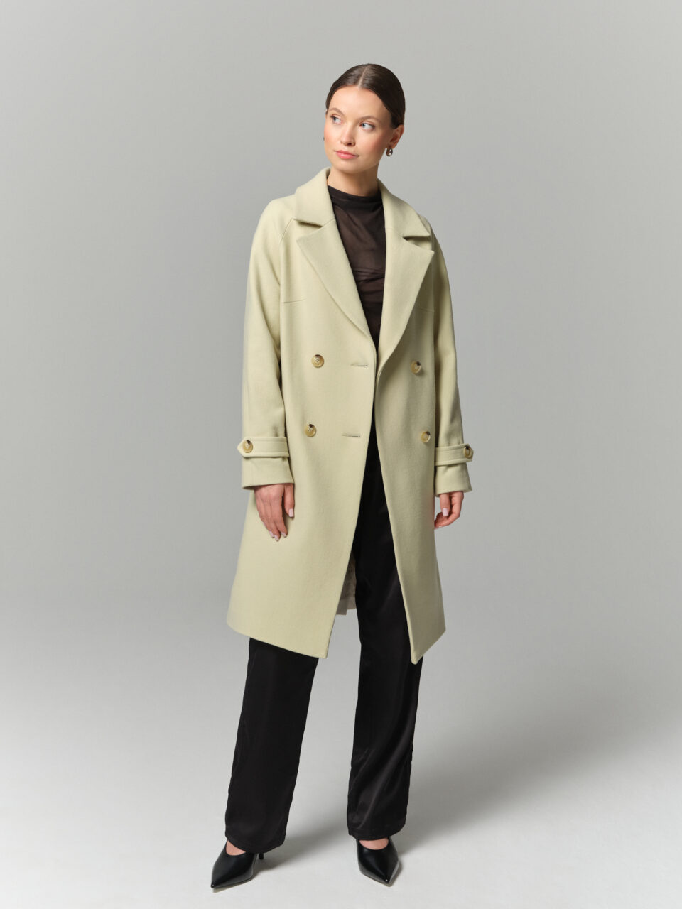 Płaszczyk przejściowy z lekkiej wełny dziewiczej w pistacjowej zieleni. Luźny, swobodny krój. Pasek i guziki.