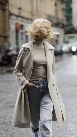 Klasyczny trencz damski zapinany dwurzędowo na guziki i wiązany. Długość w kolano. Bazowa kolorystyka.