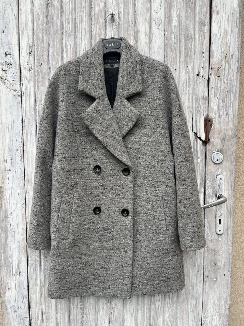 Wełniany płaszczyk do połowy uda zapinany dwurzędowo. Oversizowy. Uszyty z wełny dziewiczej i kaszmiru.