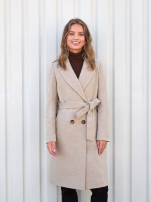 Beżowy płaszcz zimowy długość w kolano. Dopasowany, zapinany na guziki i wiązany. Idealny dla niższych osób.