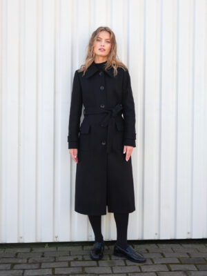 Czarny jednorzędowy płaszcz damski z wełny i kaszmiru. Dopasowany krój, z delikatnie rozkloszowanym dołem, na guziki i wiązany. Klasyk na lata.